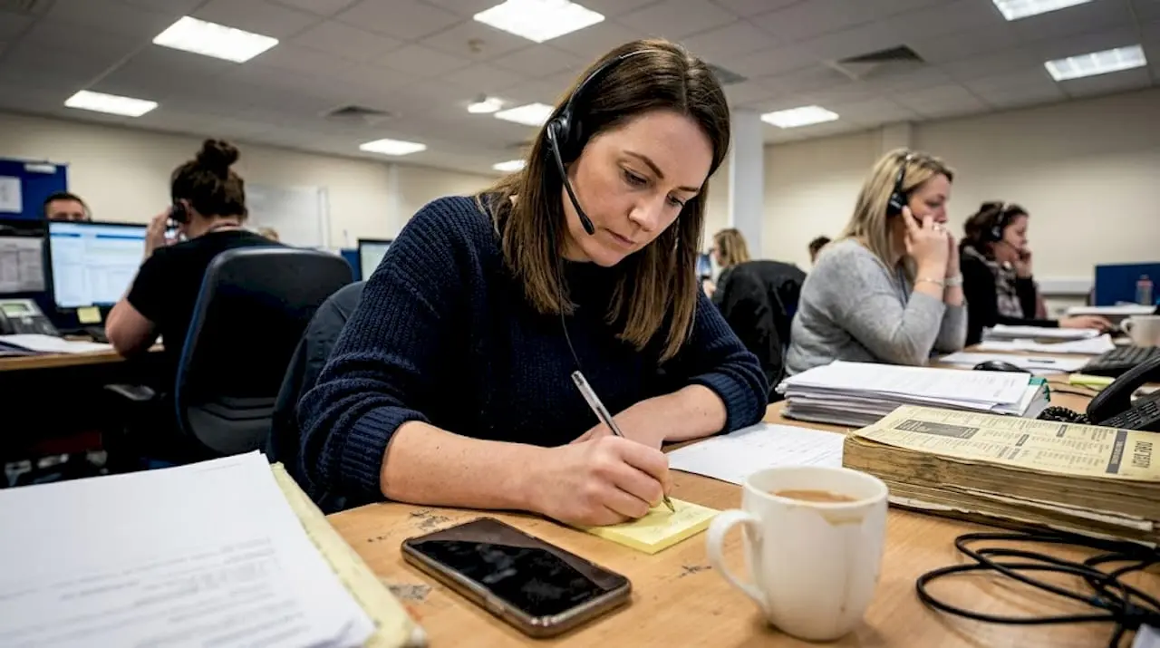 Taxi dispatcher taking booking call at desk