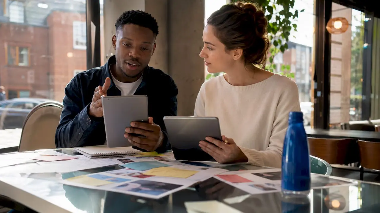 Two professionals discussing phone numbers at coworking space