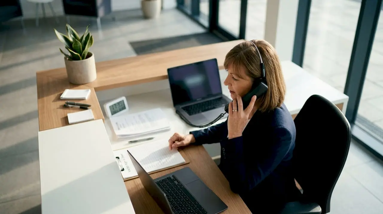 Receptionist answering office phone at front desk