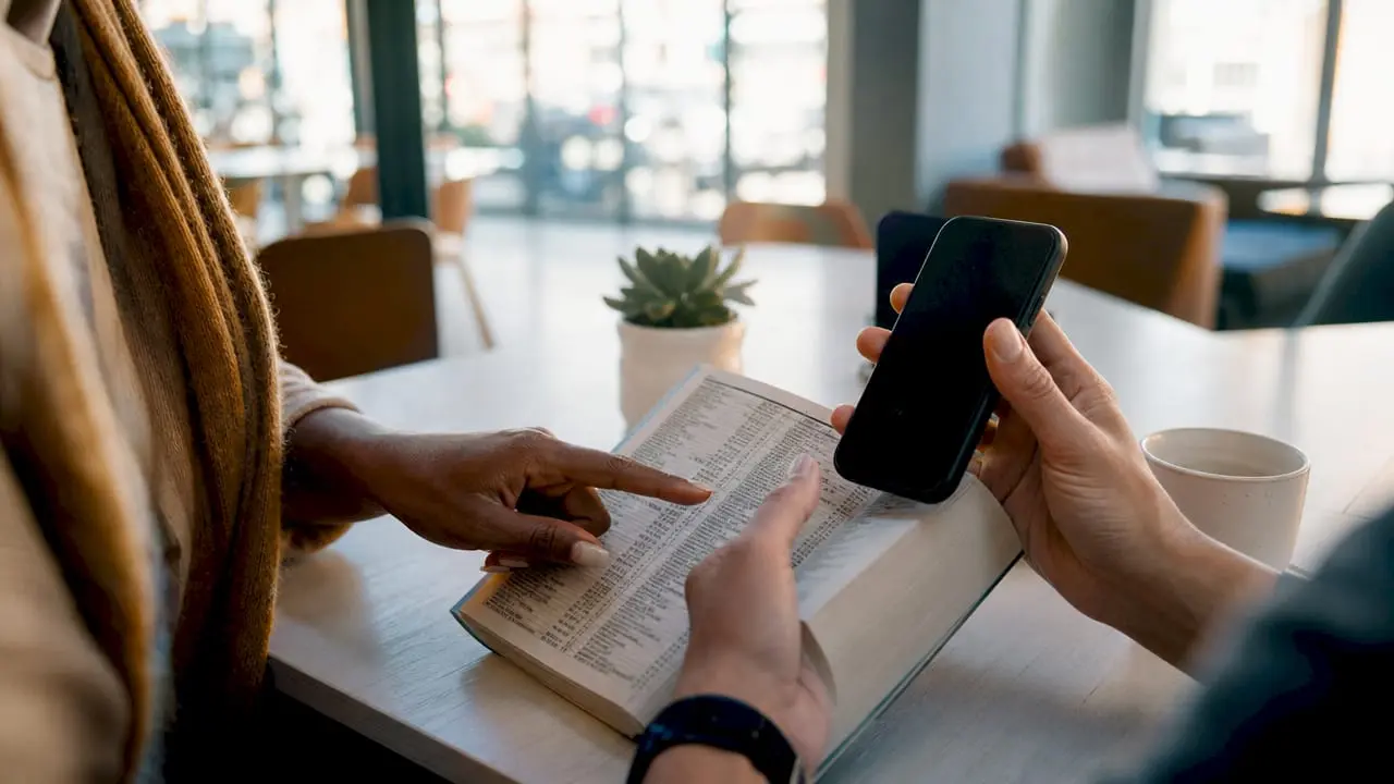 Hands holding smartphone and UK phone directory