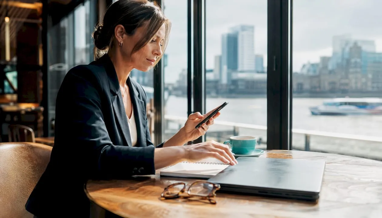 Businesswoman setting UK digital number on phone