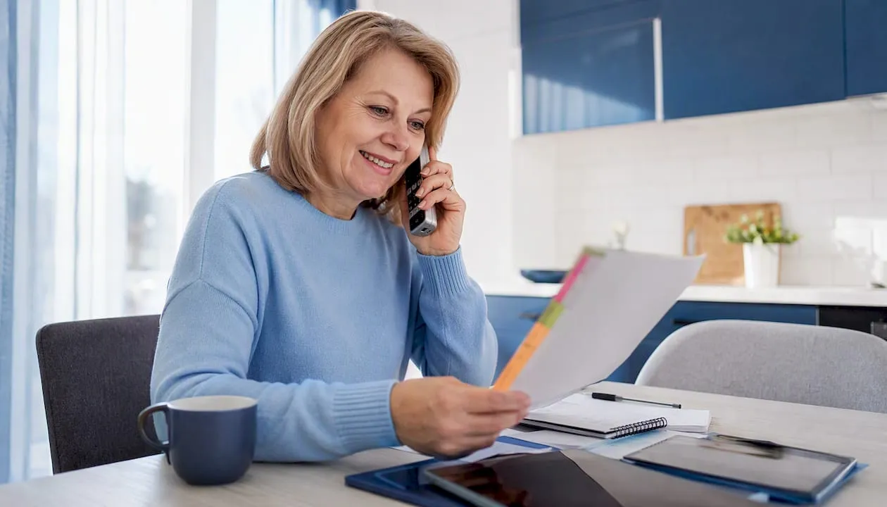 Woman reviewing UK phone numbers list at home