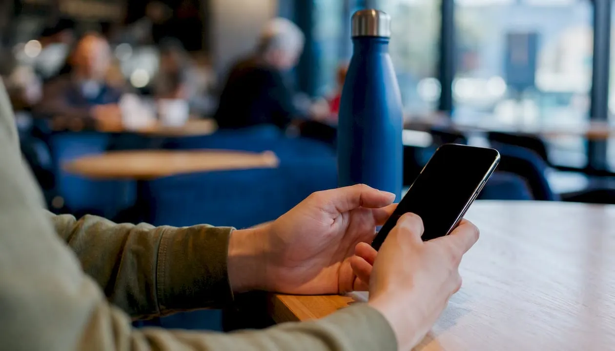 Hands holding phone in UK business setting