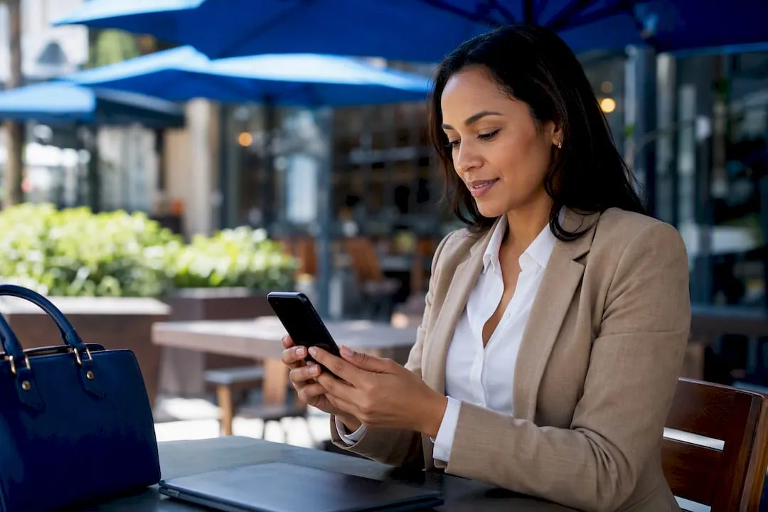 Business hand holding smartphone at desk